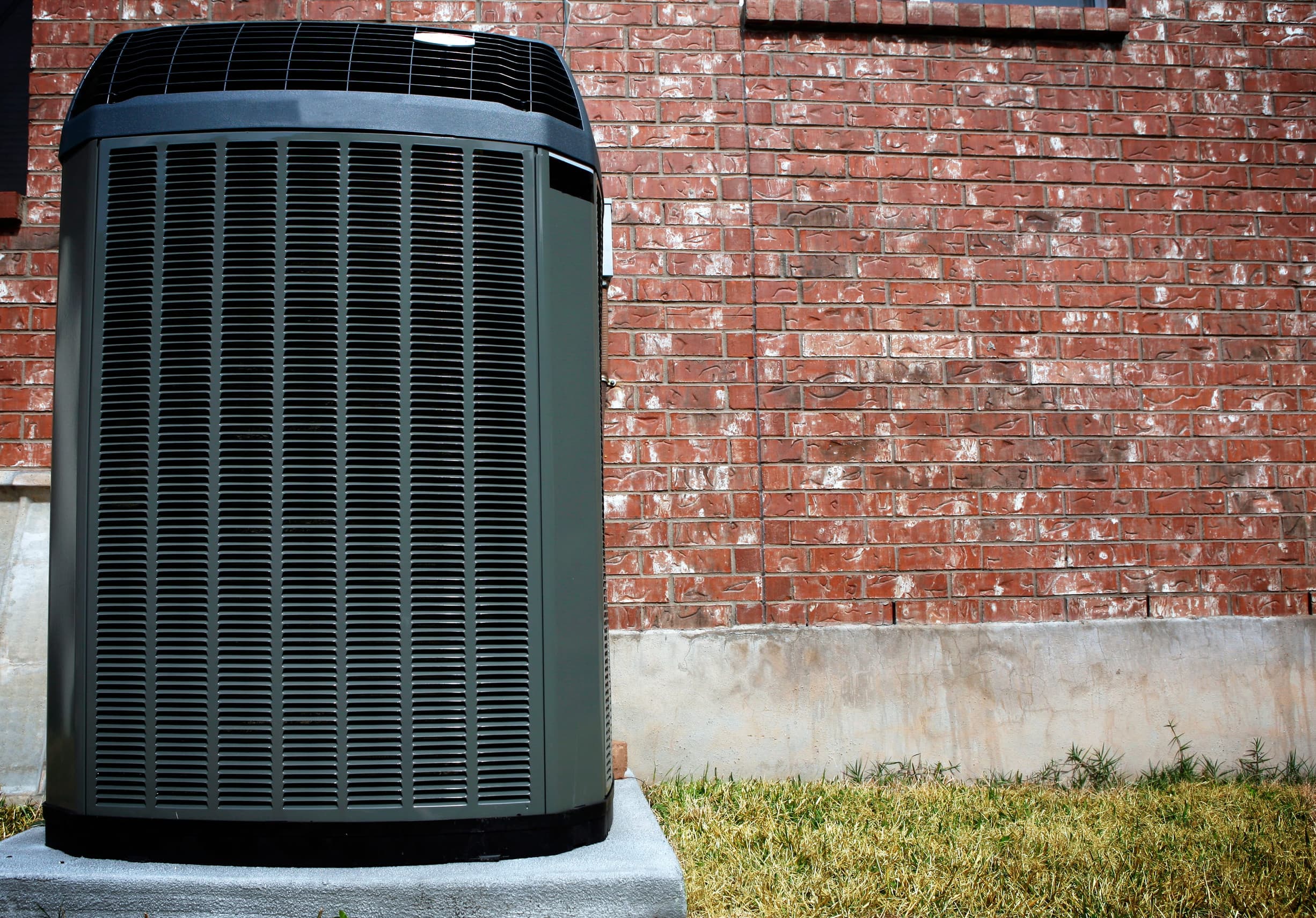 Outdoor AC condenser installed beside a home